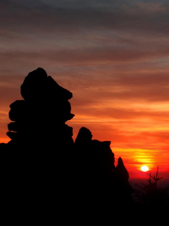 sunset and hiker cairn as seen from North Pack Monadnock mountain in New Hampshire