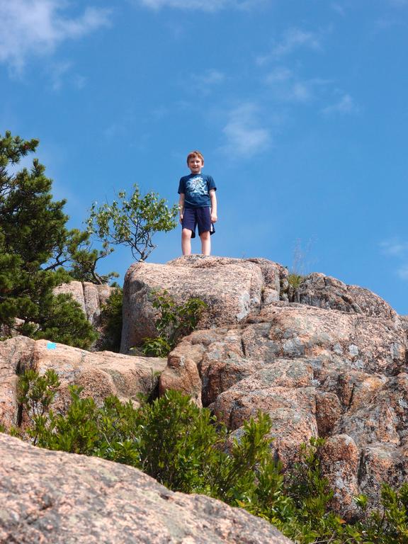 young hiker near the top of the Beehive Trail at Acadia National Park in Maine