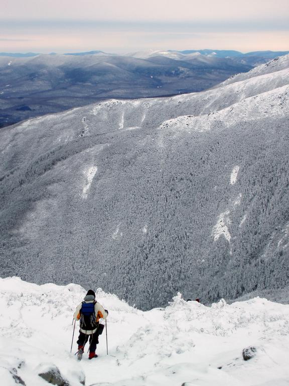 winter hiker descending Mount Monroe in New Hampshire