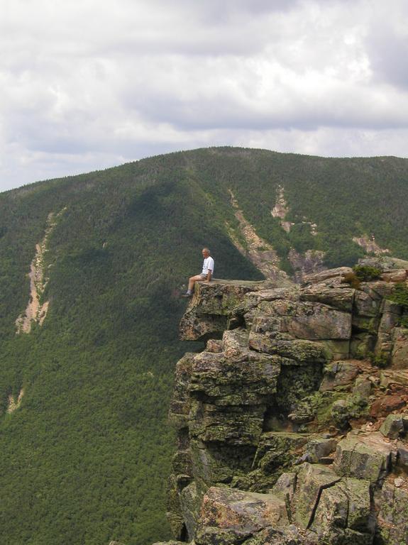hiker on the edge of Bondcliff mountain in New Hampshire