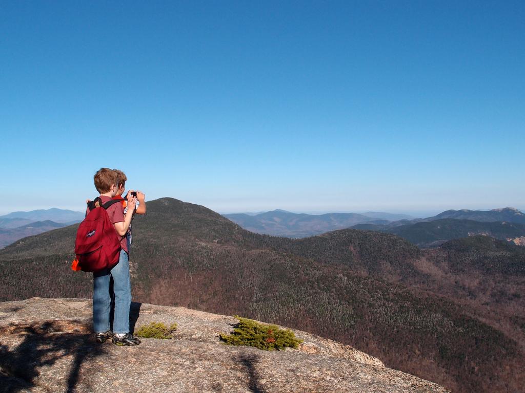 young hikers at a ledge lookout on Mount Whiteface in the Sandwich Range of New Hampshire