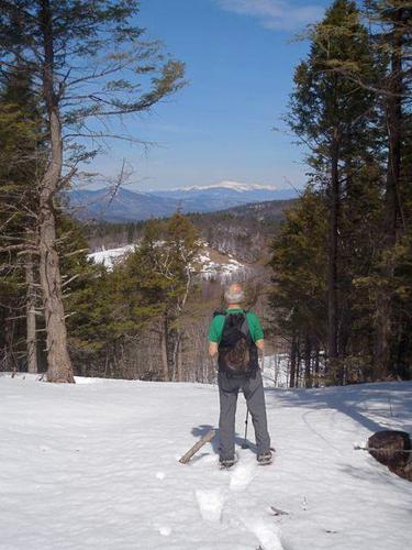 Fred takes in the north view in April from a clearing on the hike down off Lyman Mountain in New Hampshire