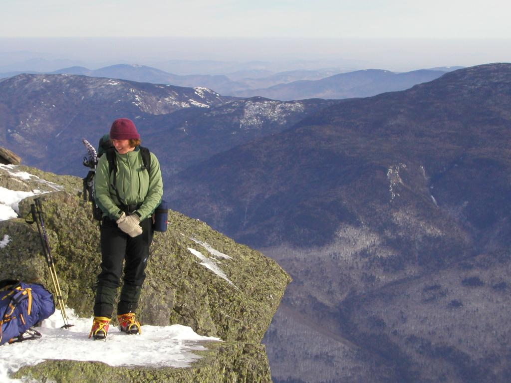 Rebecca stands out on the edge of Mount Madison in December in the White Mountains of New Hampshire