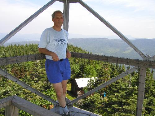 hiker and view from Magalloway Mountain's observation tower in New Hampshire