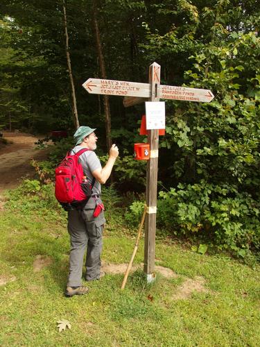 John checks out a junction trail sign at Mary's Mountain in eastern New Hampshire