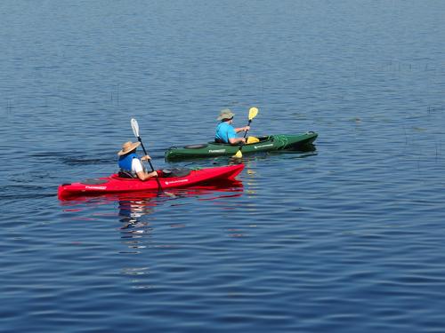 a paddler pair enjoys Massabesic Lake at the parking spot for hiking Mine Hill in southern New Hampshire