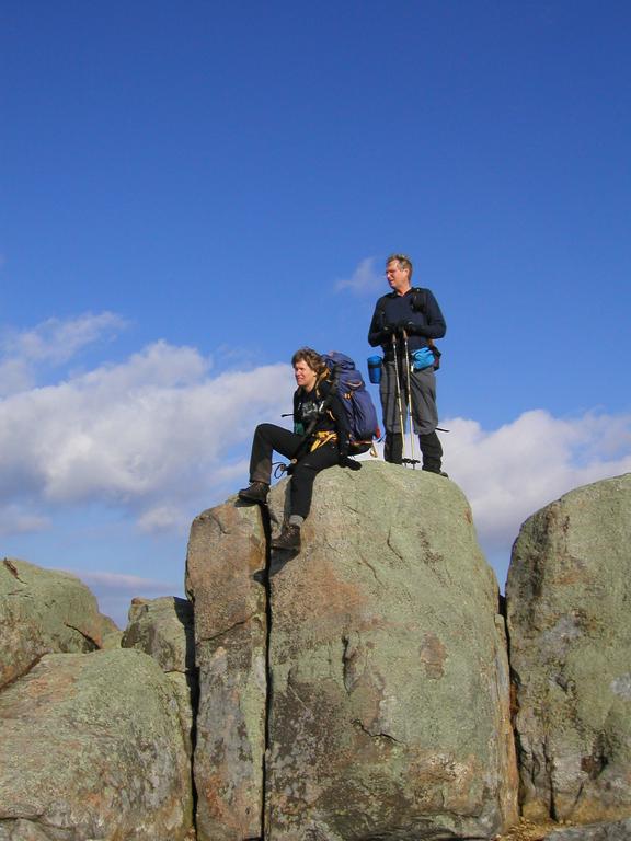 Sarah and Tom climb ridge boulders in November on Moat Mountain in New Hampshire