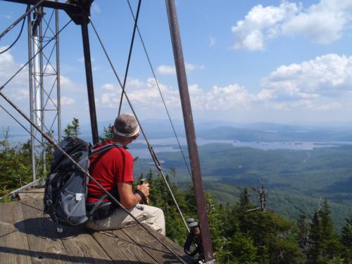 hiker at the base of the old tower on top of Big Moose Mountain in Maine