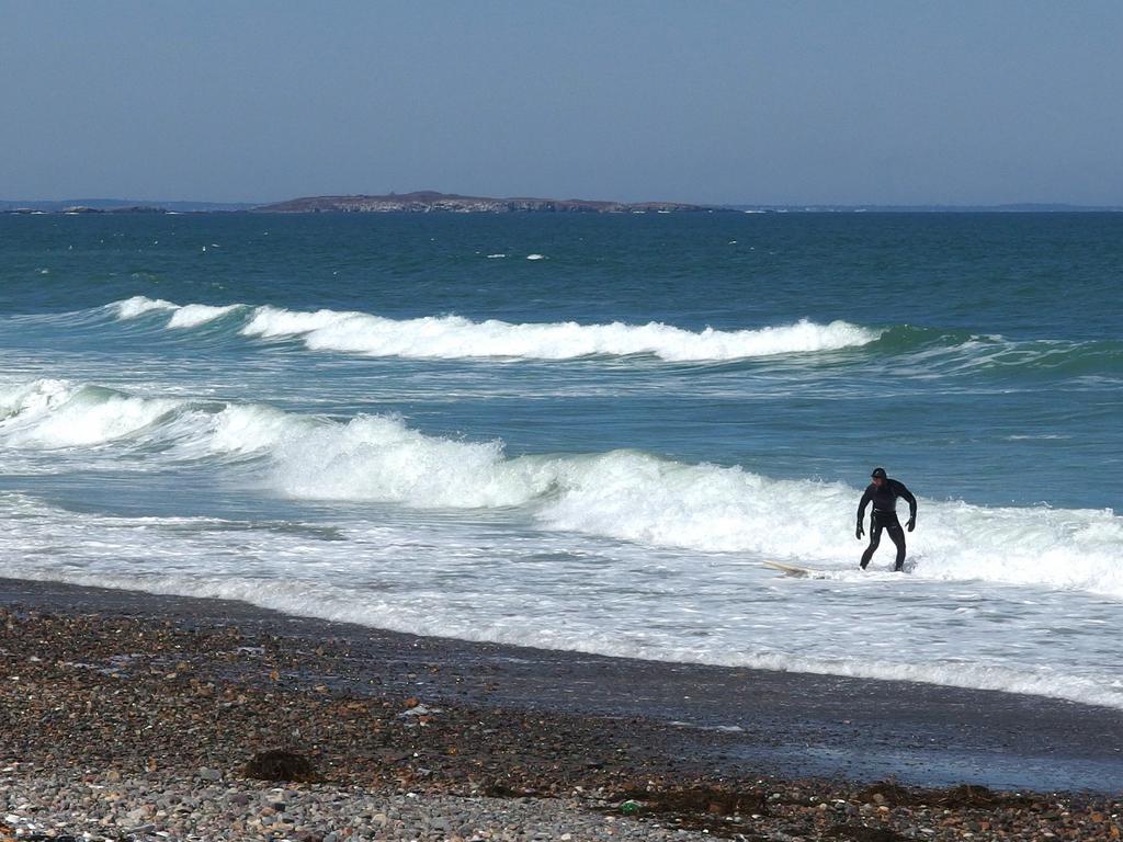 April surfer on Nantasket Beach at Hull in Massachusetts