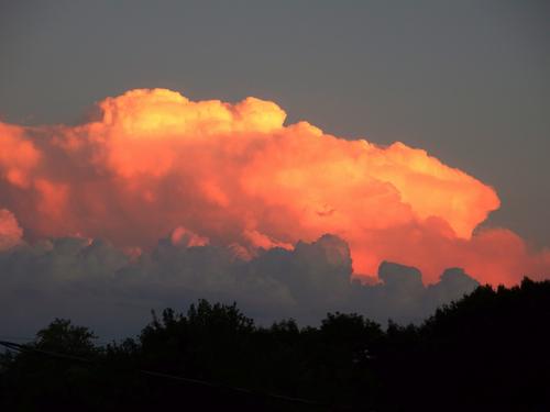 an unusual sunset scene: storm cloud beneath and blazing gold on top in July at Nashua in New Hampshire