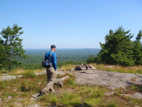 hiker at a viewpoint on Nottingham Mountain in New Hampshire