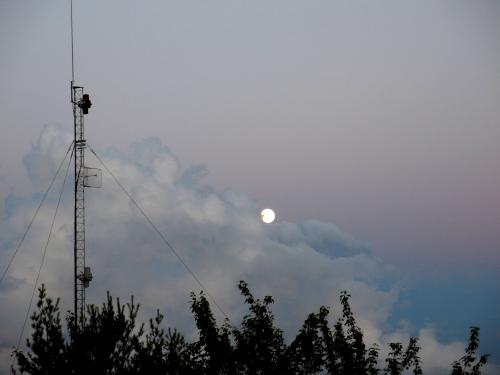 moonrise at sunset in July as seen from the fire tower atop Oak Hill near Concord in New Hampshire