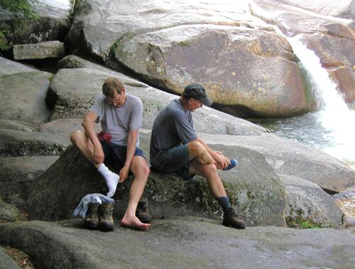 hikers changing socks at Franconia Falls in New Hampshire
