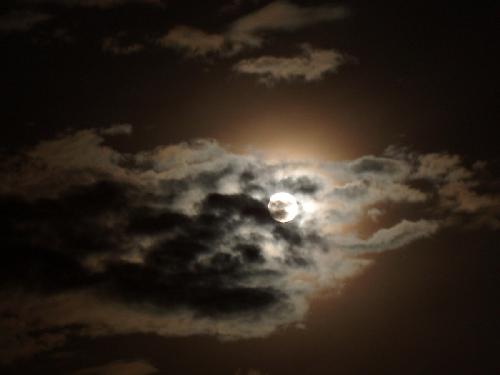full moon peeking through clouds