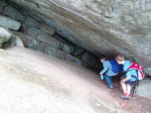 young hikers explore a cave on Pawtuckaway North Mountain in New Hampshire