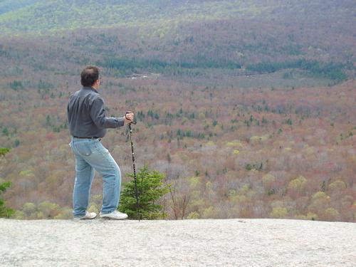Adrian enjoys the spring foliage view as seen from the cliff edge on Mount Pemigewasset in New Hampshire