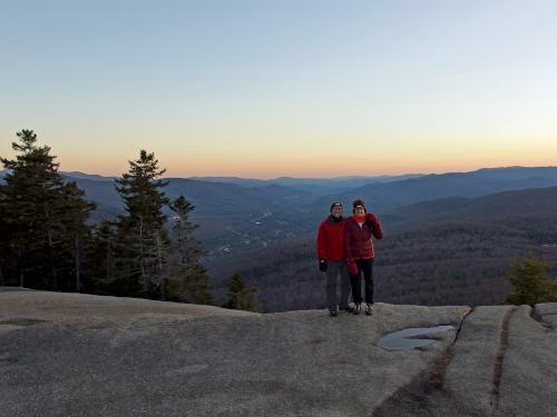 Larry and Cathy on the ledge edge just after sunset in November on Mount Pemigewasset in New Hampshire