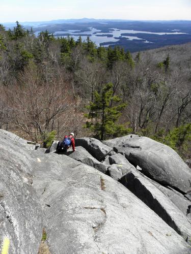 hiker descending the cliffs on Mount Morgan in New Hampshire