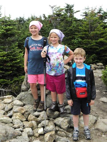 young hikers at the summit cairn on Mount Pierce in New Hampshire