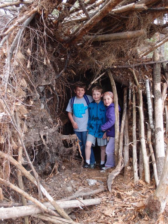 Garrett, Carl and Talia inside the root fort on Hooksett Pinnacle in southern New Hampshire