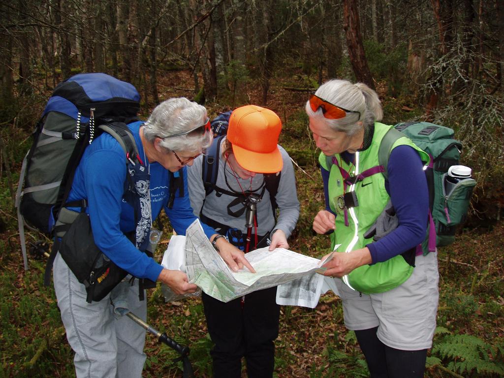 Anne, Erica and Lisa check map and compass on a bushwhack to Mount Pliny in New Hampshire