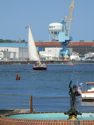 a Gundalow sailing barge brings tourists back toward dock at Portsmouth Harbor in New Hampshire