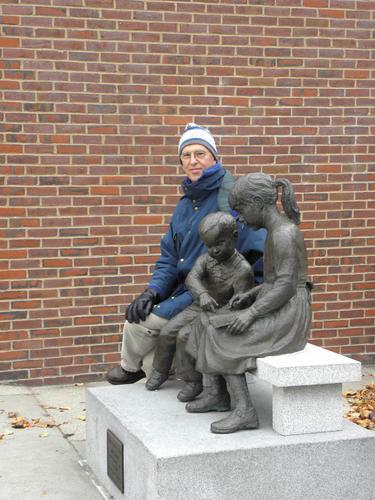 visitor at the library statue at Nashua Riverwalk in New Hampshire