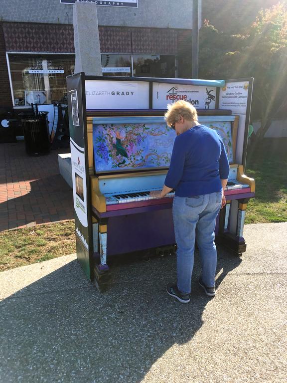 Andee plays a sidewalk piano on Main Street while on the Nashua Riverwalk in New Hampshire