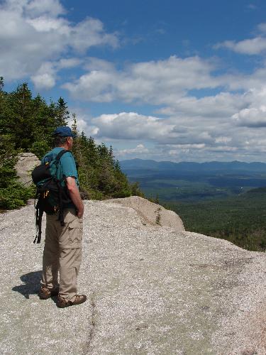 hiker and view from Rogers Ledge in New Hampshire