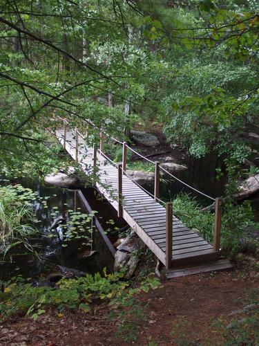 a picturesque pedestrian bridge crosses wetlands at Cutter Woods in southern New Hampshire