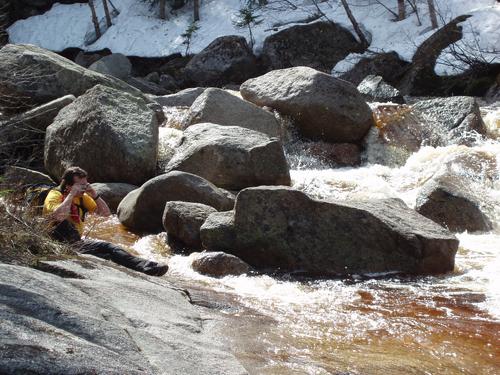 photographer on the water's edge near Thoreau Falls in New Hampshire
