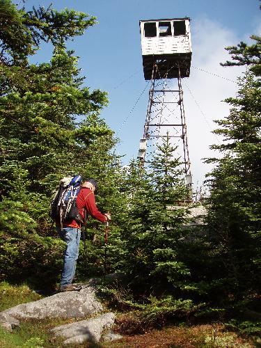 hiker and broken tower on Snow Mountain in Maine