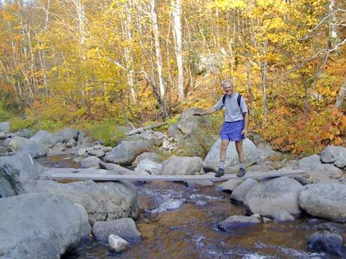 hiker crossing the South Branch of the Carrabassett River in Maine