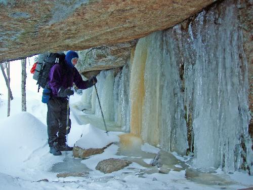 hiker on the icy trail to Square Ledge in New Hampshire