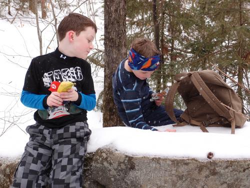 winter hikers stopping for a snack on the trail to Mount Sunapee in New Hampshire
