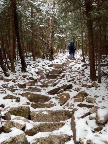 winter hiker on the trail to Mount Tecumseh in New Hampshire