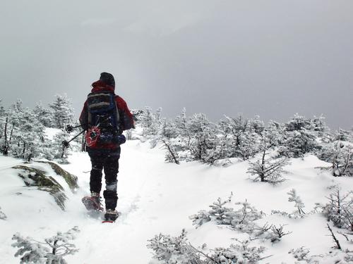 a winter hiker heads down from the summit of South Twin Mountain in New Hampshire