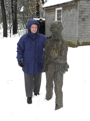 visitor by Thoreau statue at Walden Pond in Massachusetts