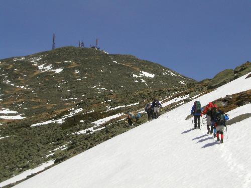 hikers crossing a snowfield to Mount Washington in New Hampshire