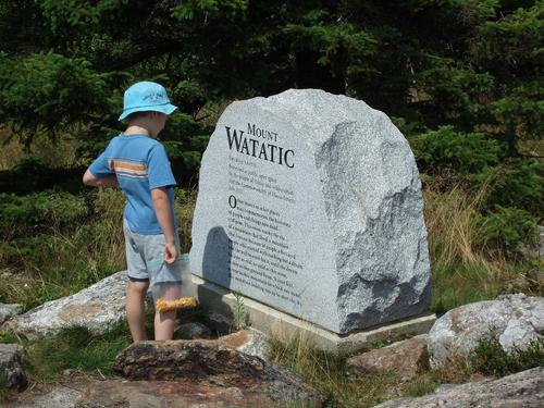 hiker at summit monument on Mount Watatic in Massachusetts
