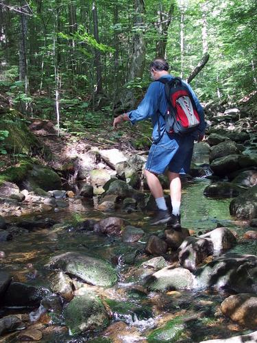 Lance crosses Walker Brook on the way to the B-18 Bomber Crash Site on Mount Waternomee in western New Hampshire