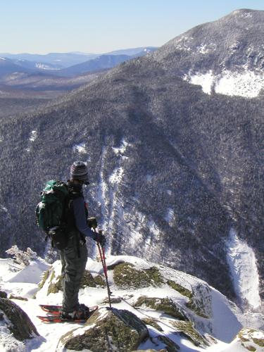 hiker and winter view from Mount Webster in New Hampshire