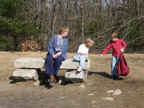 visitors at the stone bench atop Weir Hill in Massachusetts