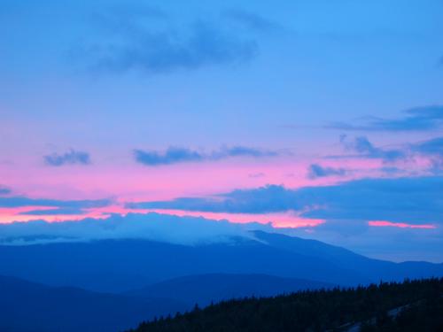 pink sunset over cloud-enshrouded Mount Moosilauke as seen from Welch Mountain in New Hampshire