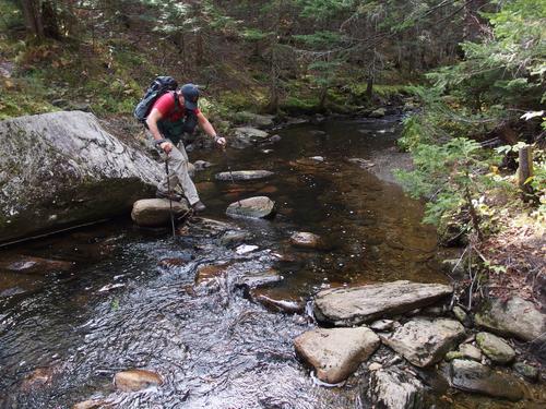 crossing a brook on the trail to Whiteface Mountain in northern Vermont