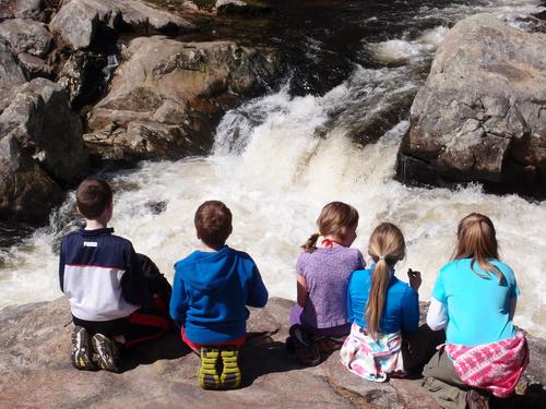 young hikers on snack break in front of Wildcat Falls in southern New Hampshire