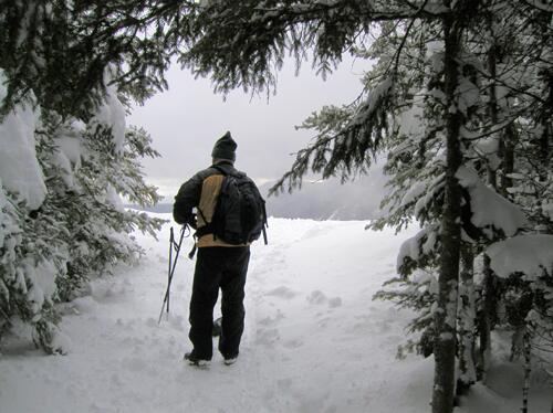 a winter hiker emerges onto Mount Willard's ledge in New Hampshire