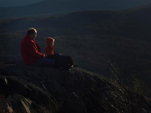 hikers atop Winn Mountain in New Hampshire at sunset