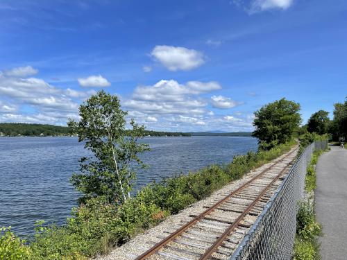 WOW Rail Trail in June beside active rail tracks passing by Lake Winnisquam in central New Hampshire