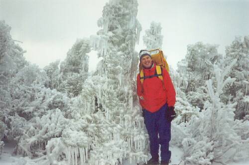 hiker and ice-coated trees on Zeacliff in New Hampshire